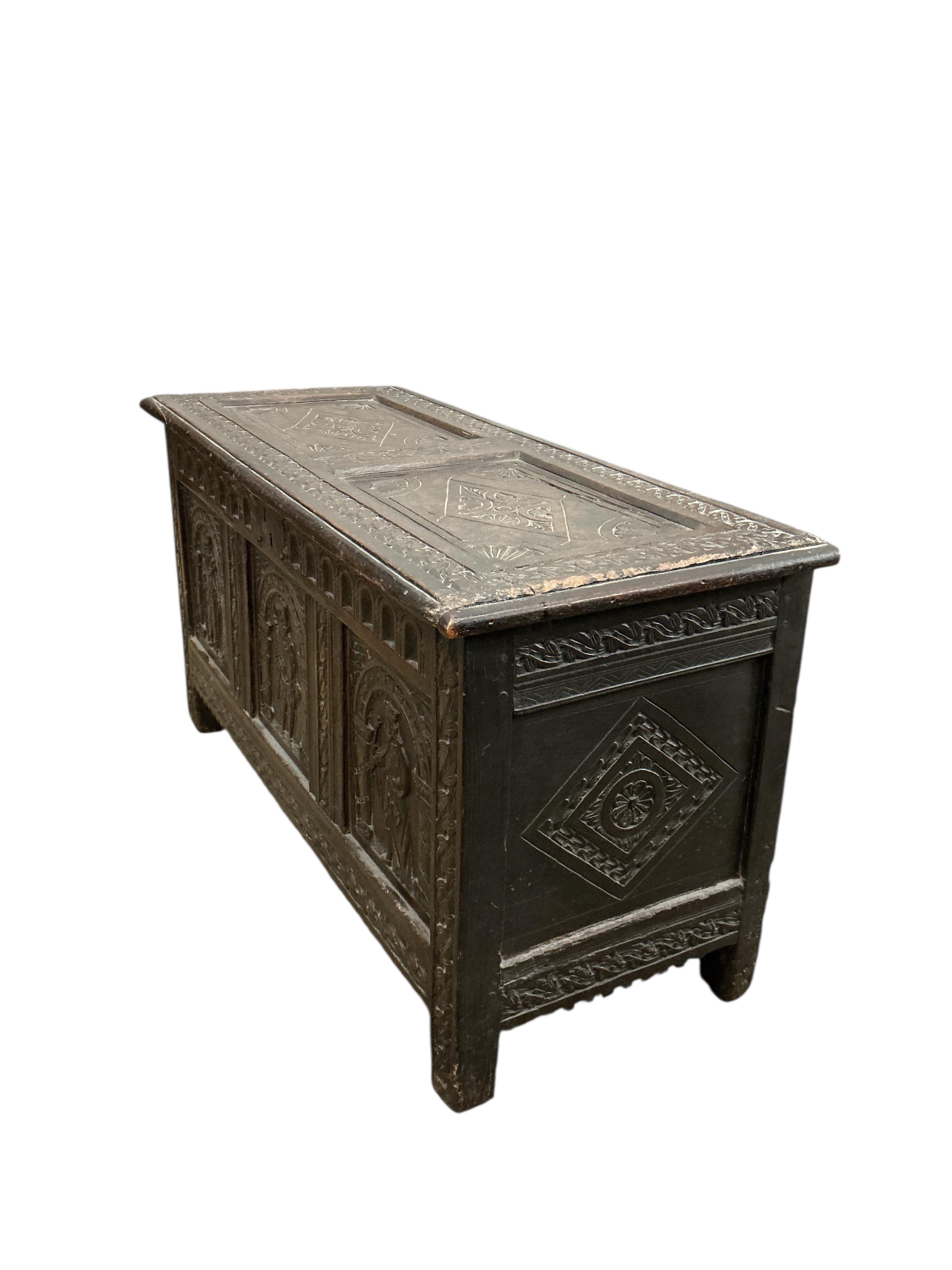 An 18th century oak panelled coffer, later carved, width 116cm, depth 49cm, height 64cm